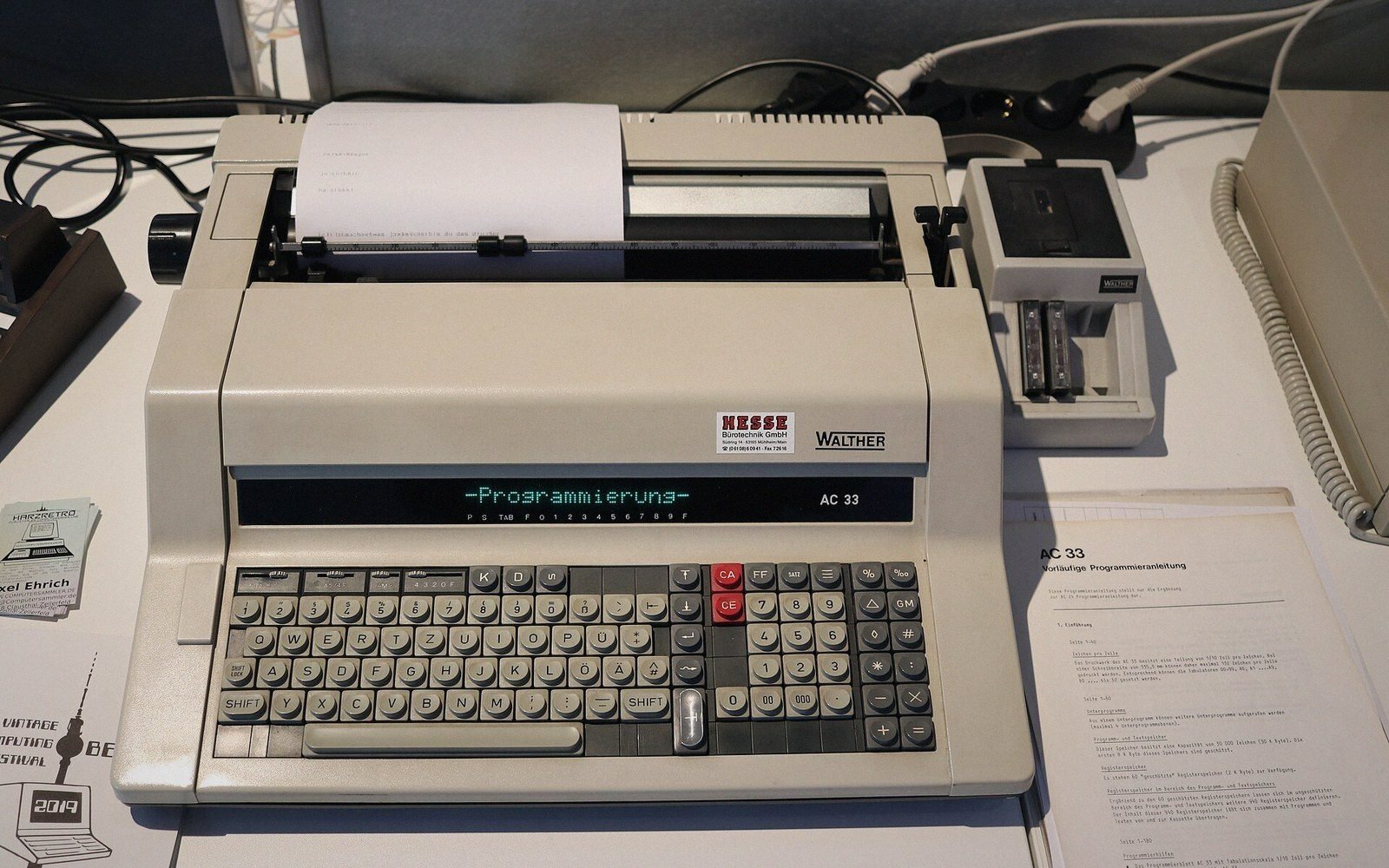 A Walther AC 33 electronic typewriter with a digital display showing "Programmierung" on its keyboard panel