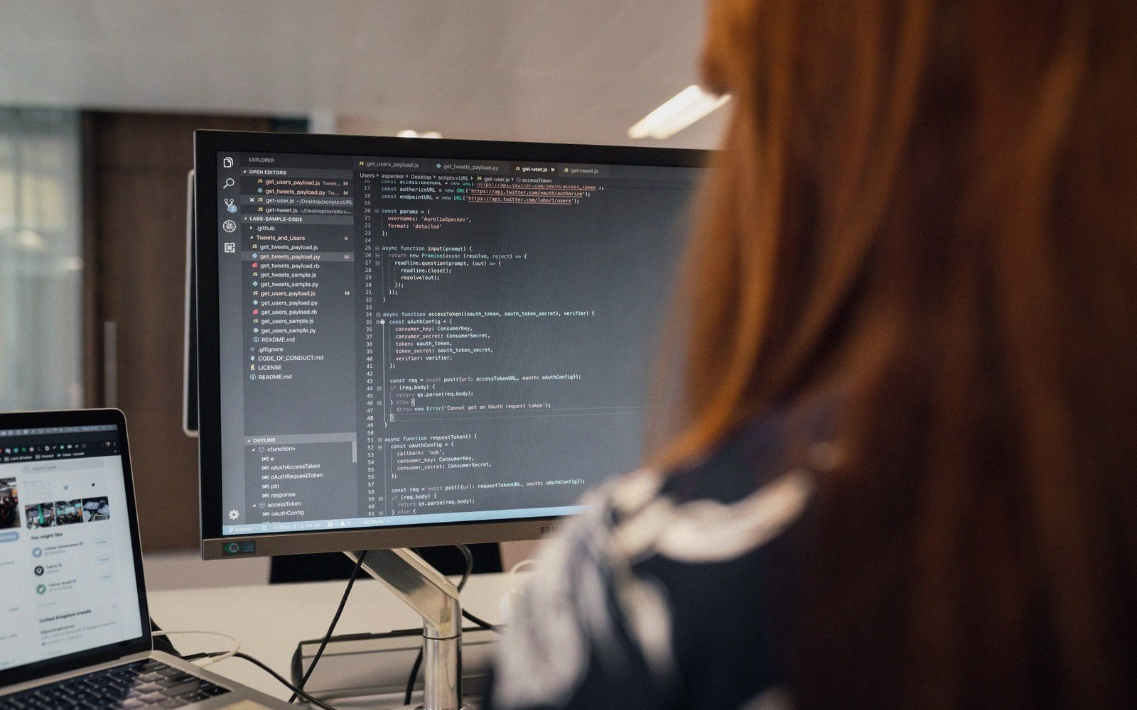 A person views lines of code in a text editor on a desktop monitor