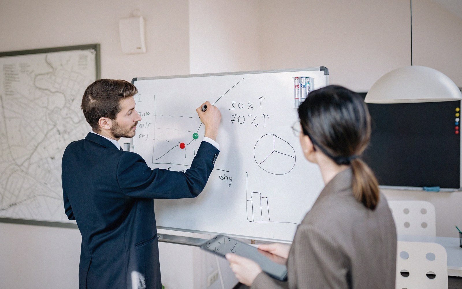 A whiteboard of architecture diagrams with two people at it